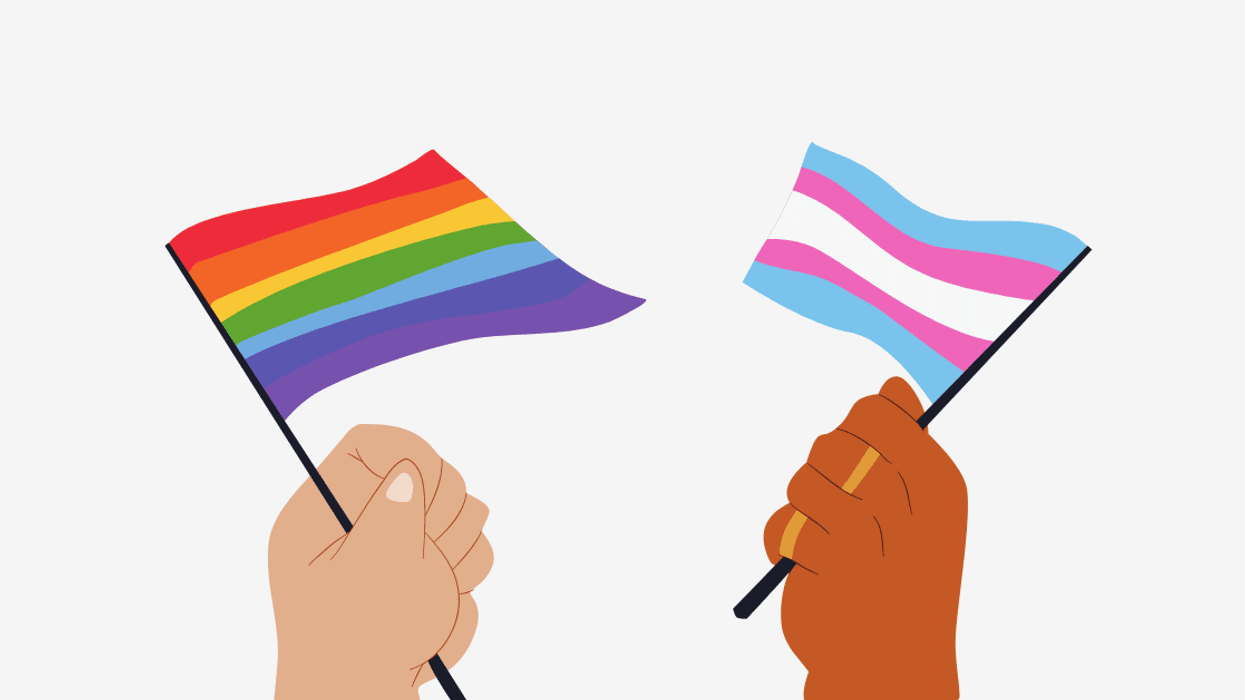two hands holding an lgbtqia flag and a trans flag