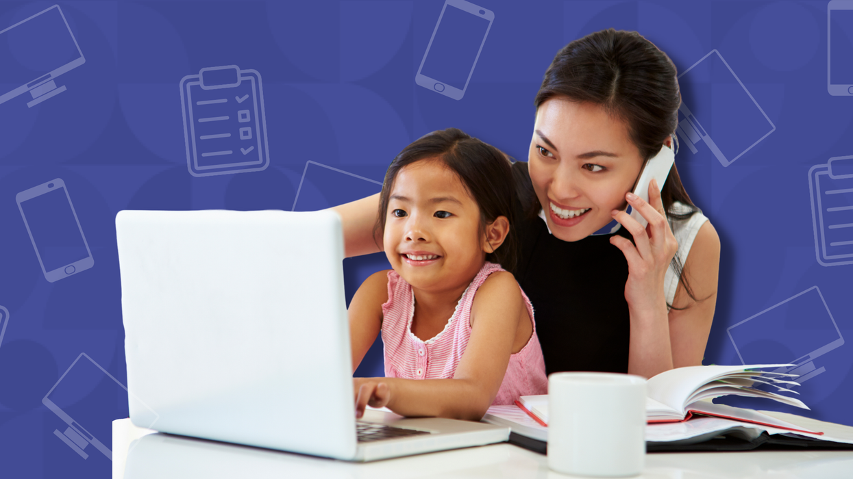 Woman on the phone with her daughter sitting in her lap working on the computer