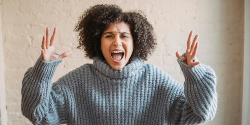 Woman with hands up in the air, looking very frustrated